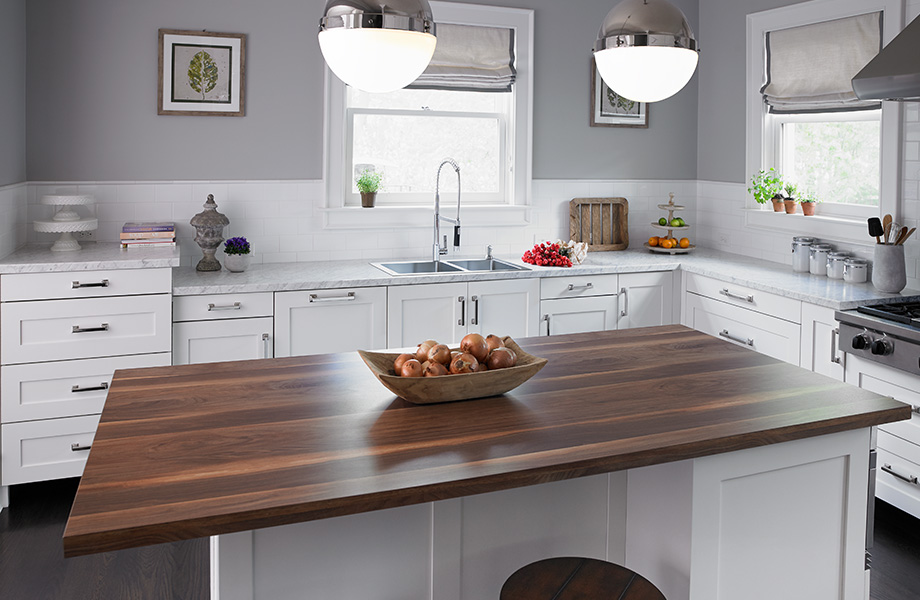 Large white kitchen with island in Wide Planked Walnut 180fx Laminate and countertops in Carrara Bianco Formica Laminate